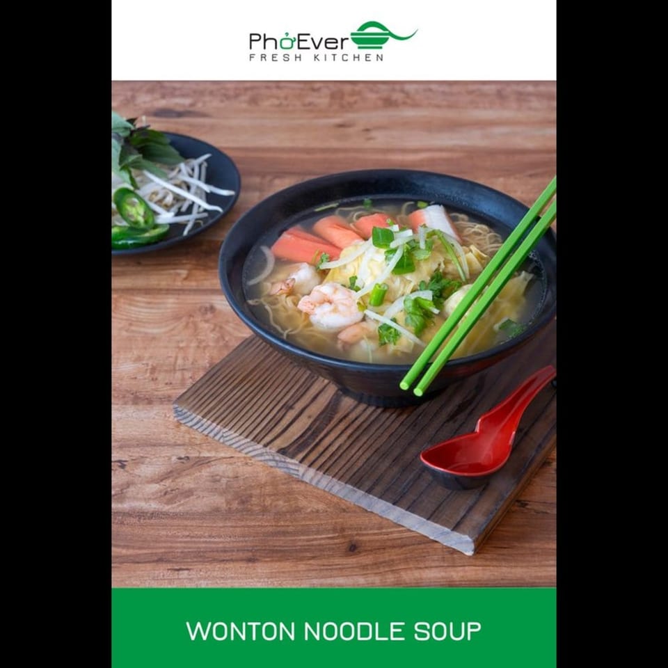 Wonton Noodle Soup with shrimp, crab, and vegetables, served with green chopsticks and a red spoon.